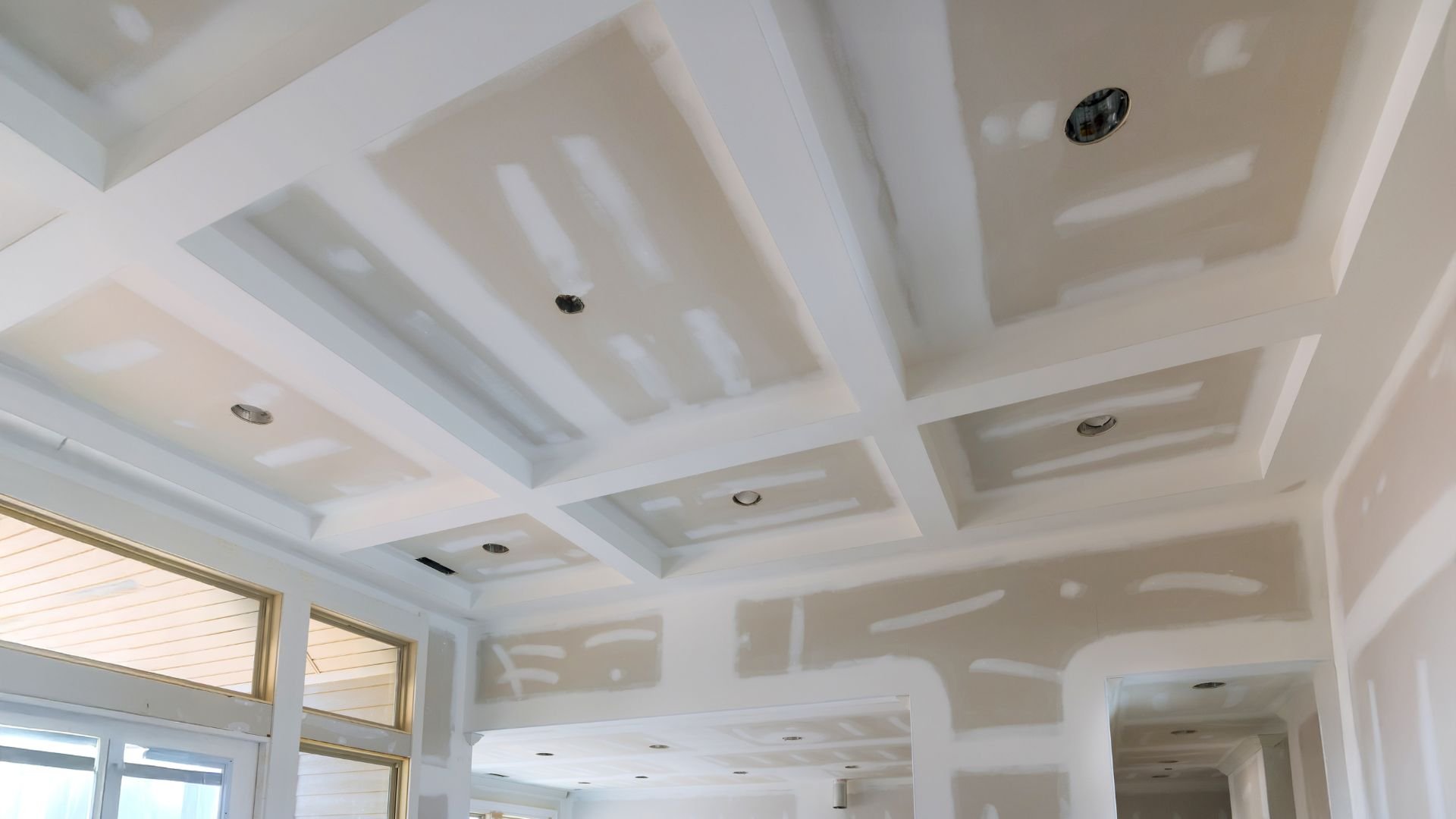 White coffered ceiling with recessed lights in modern interior space