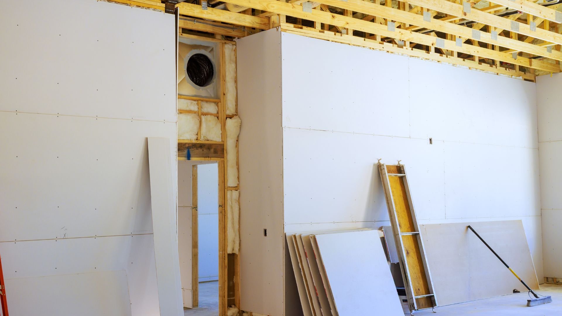 Interior room under construction with drywall, wooden framing, and insulation