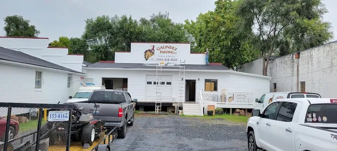 Salindez Fencing white business building with parked trucks in gravel lot
